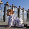 Migranti, baby profuga gattona verso la polizia. Il tenero e drammatico scatto diventa virale