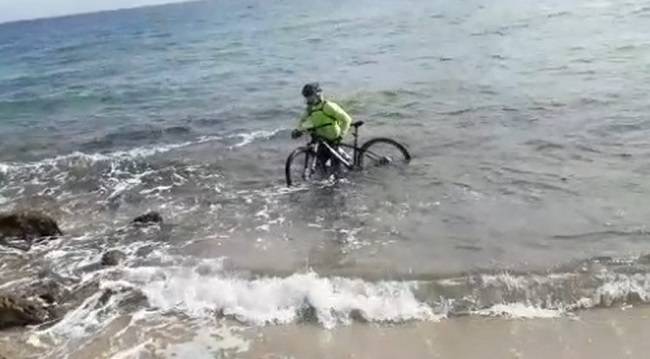 Coronavirus, ciclista entra in mare con la sua bici per cercare di evitare un controllo